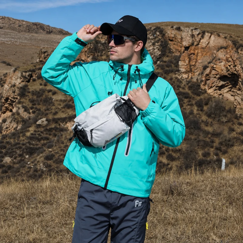 Sac banane blanc porté en bandoulière sur la poitrine par un homme lors d'une randonnée en montagne