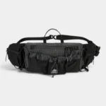 Sac banane noir en ripstop quadrillé posé de face avec sa poche frontale en filet à cordon élastique