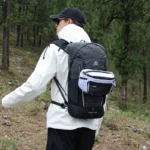 Sac Banane Trekking Imperméable Accrochable Sac banane ripstop blanc accroché sur un sac à dos porté par un homme en randonnée en forêt