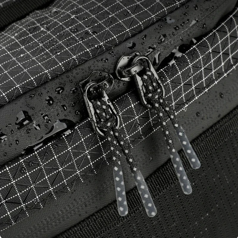 Sac banane ripstop noir en gros plan avec gouttes d'eau sur le tissu et tirettes en cordon tressé