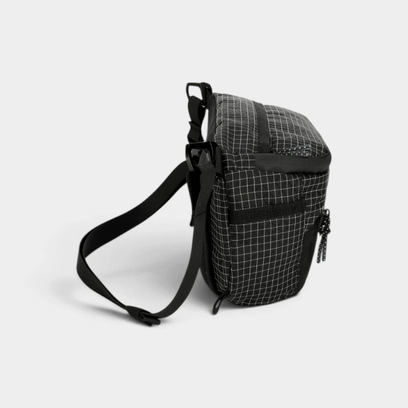 Sac banane ripstop noir quadrillé vu de côté avec passant en sangle sur le flanc et ceinture noire