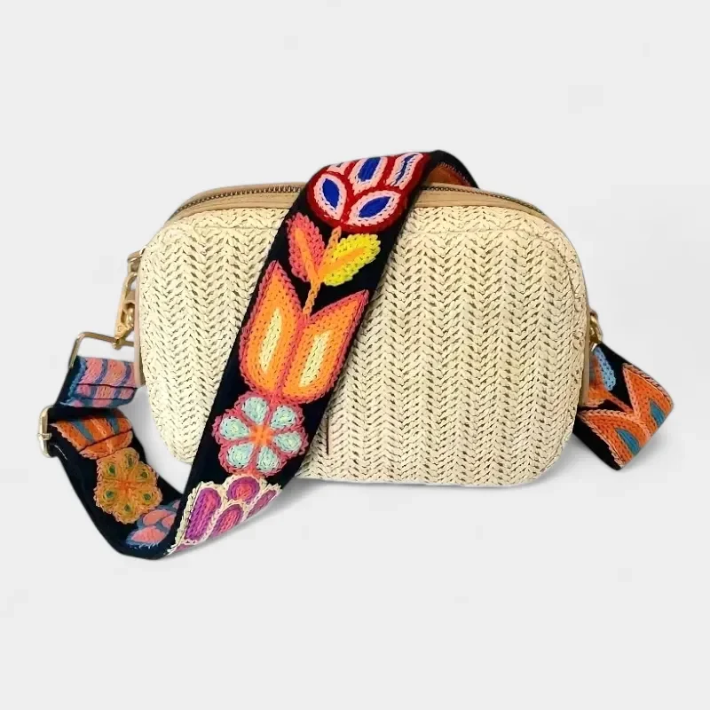 Bandoulière Brodée Bohème Motifs Floraux noire à fleurs multicolores avec mousquetons métallisés dorés, posée sur un sac clair.