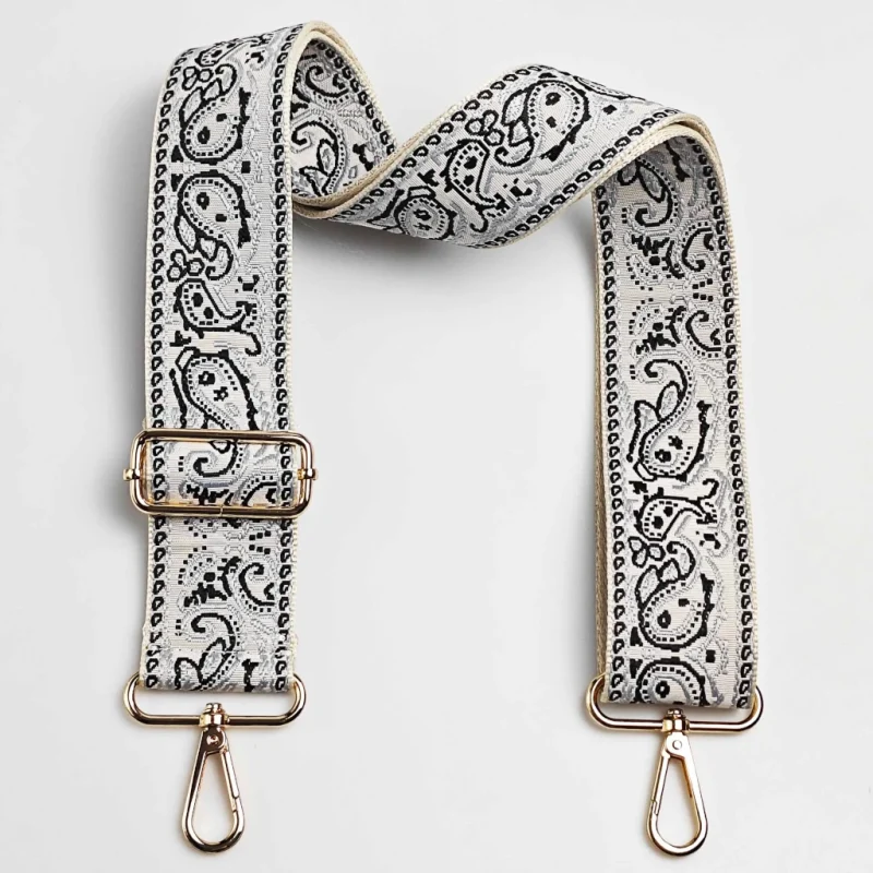Bandoulière large réglable motif paisley bandana blanc et noir posée à plat avec mousquetons et boucle de réglage dorés