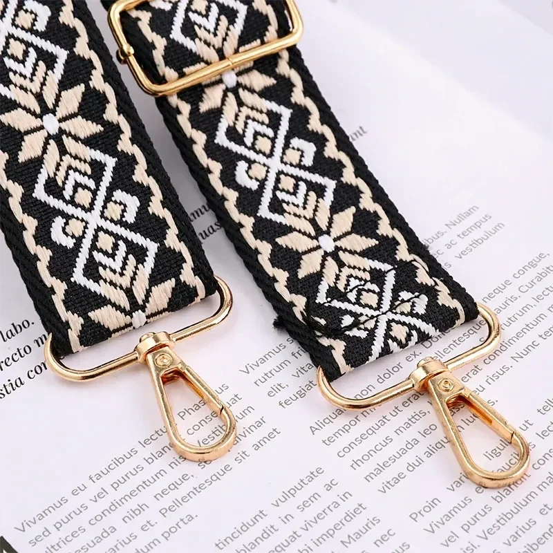 Bandoulière Motifs Jacquard Nordique avec mousquetons dorés, détails tissés noirs et beiges sur fond blanc.