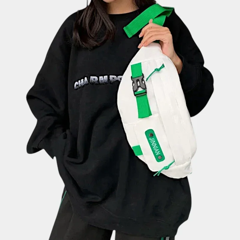 Sac banane techwear en nylon blanc porté en bandoulière sur la poitrine par une femme de face
