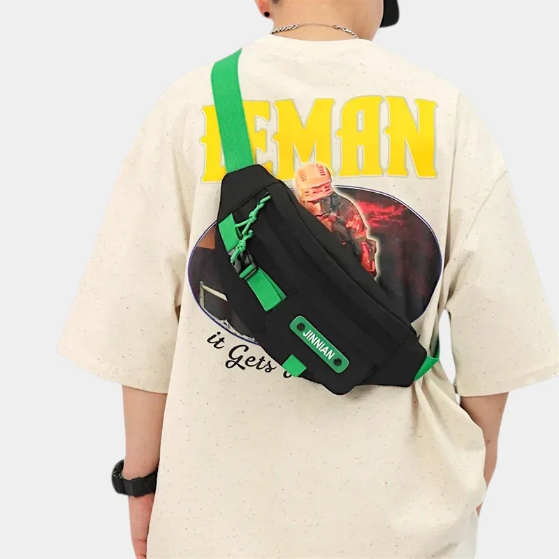 Sac banane techwear en nylon noir porté en bandoulière dans le dos par un homme au style streetwear