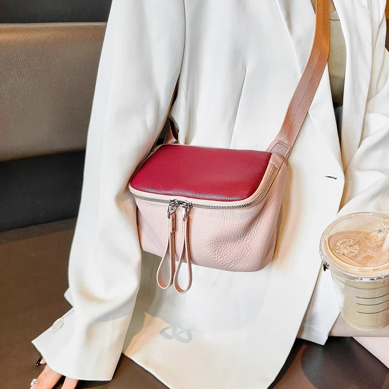 Sac à Main Banane Cuir Femme en cuir rose et bordeaux porté en bandoulière avec une boisson