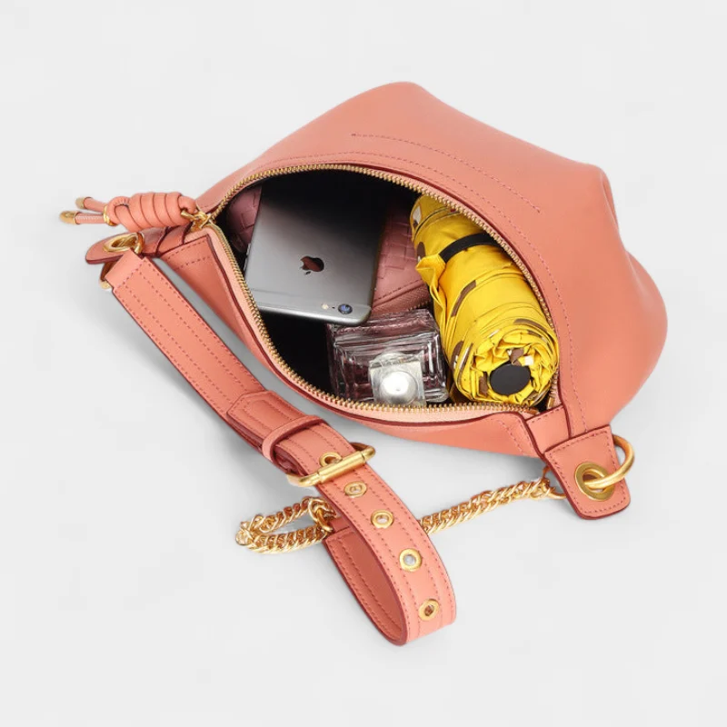 Sac Banane Cuir Coloré rose ouvert avec un téléphone un parapluie jaune et du maquillage à l'intérieur