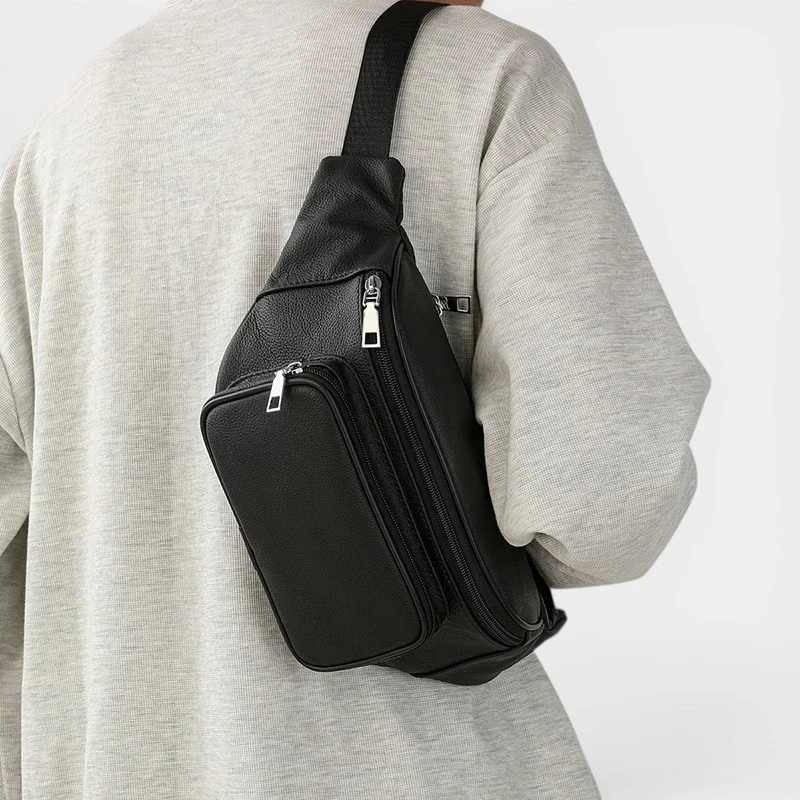 Sac banane en cuir grainé noir porté en bandoulière dans le dos par un homme au style casual-chic