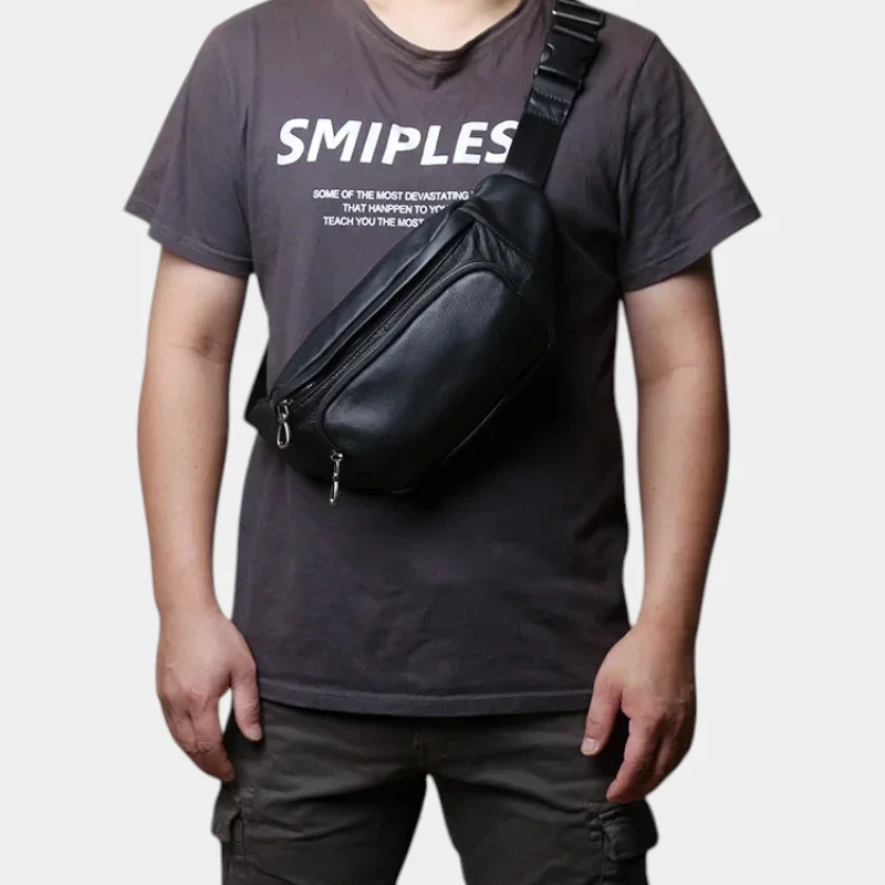Sac banane cuir noir porté en bandoulière par un homme de face avec sangle à boucle plastique