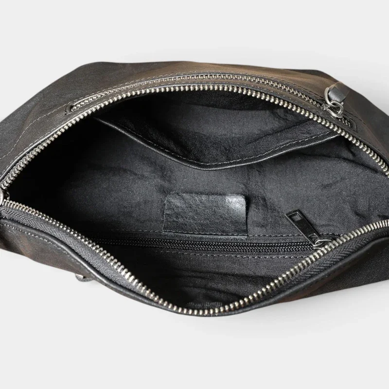 Grand sac banane cuir noir homme face vu de dessus, poche principale ouverte révélant poches zippées intérieures