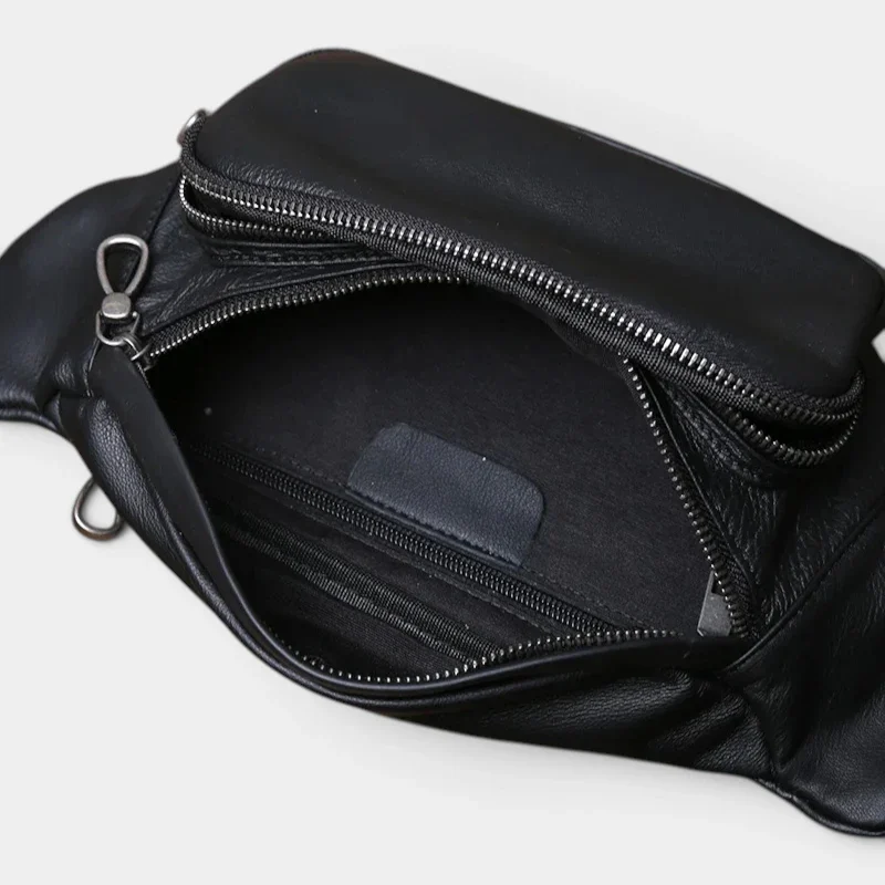 Sac banane cuir noir souple vu de dessus poche principale ouverte, intérieur avec poches zippées apparentes