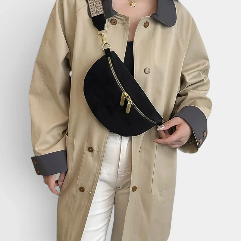 Sac banane noir en simili cuir porté en bandoulière par une femme au style chic avec sangle à motif et zip doré