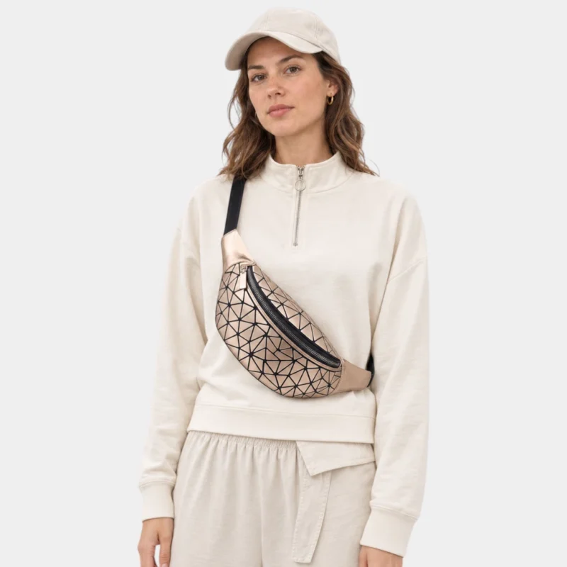 Sac banane à facettes géométriques doré métallique porté en bandoulière par une femme au style sportswear chic