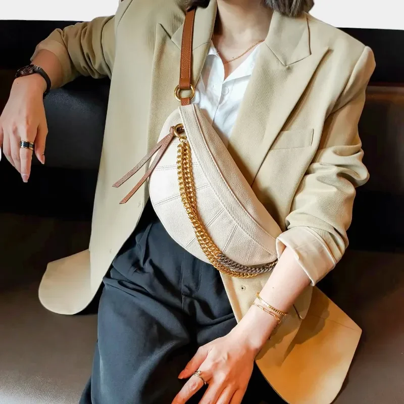 Sac Banane Femme Cuir Chaîne Dorée couleur beige porté en bandoulière avec une lanière en cuir dans un style chic