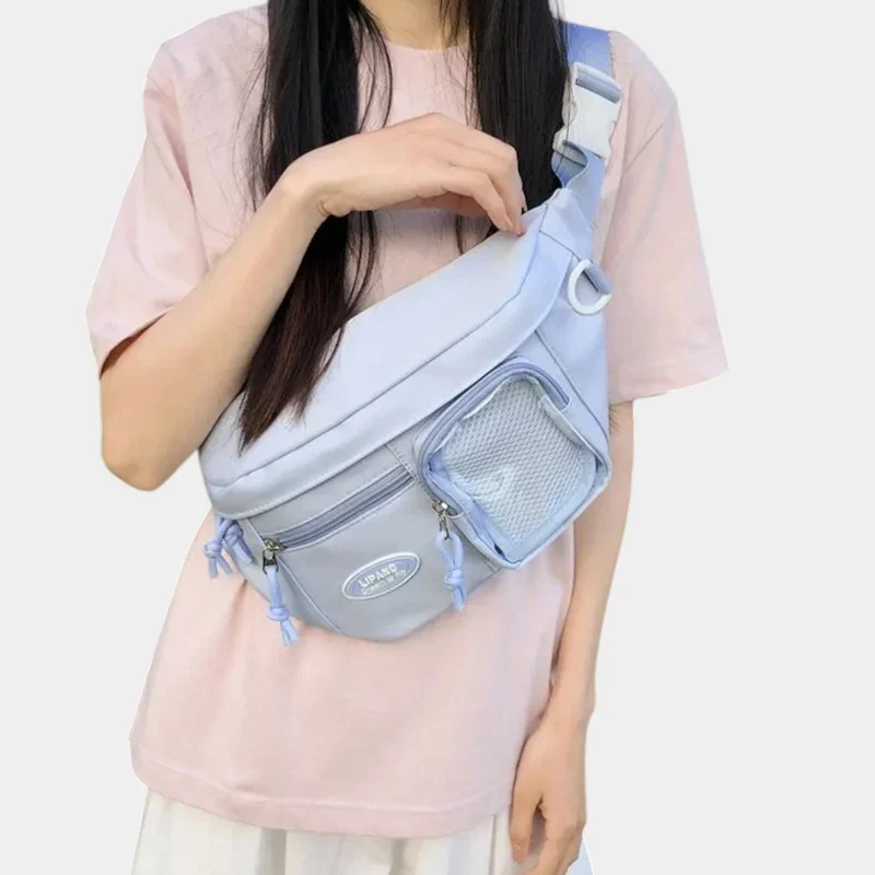 Grand sac banane femme en nylon bleu pastel porté en bandoulière croisée par une femme au style kawaii