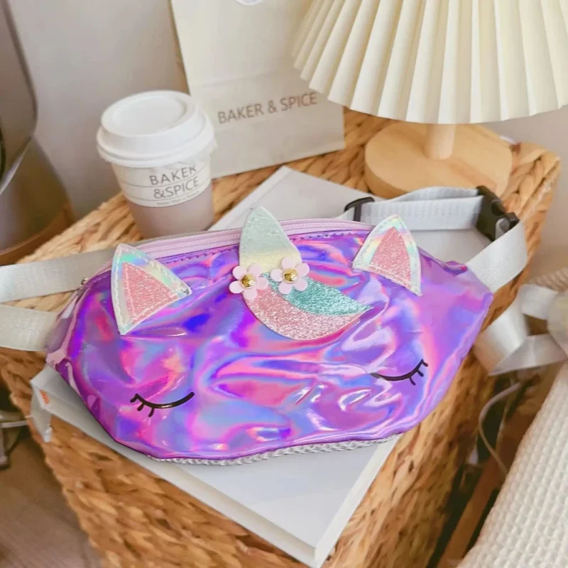 Sac banane licorne holographique violet posé sur un panier en osier près d'une lampe de chevet