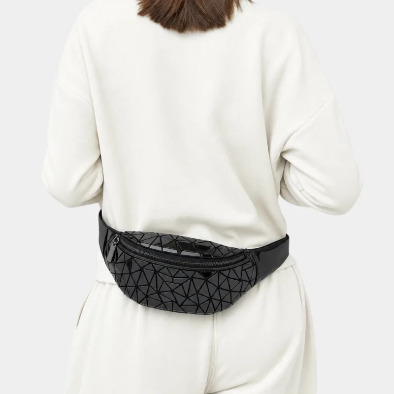 Sac banane géométrique noir brillant en PVC porté à la taille par une femme, vue de dos