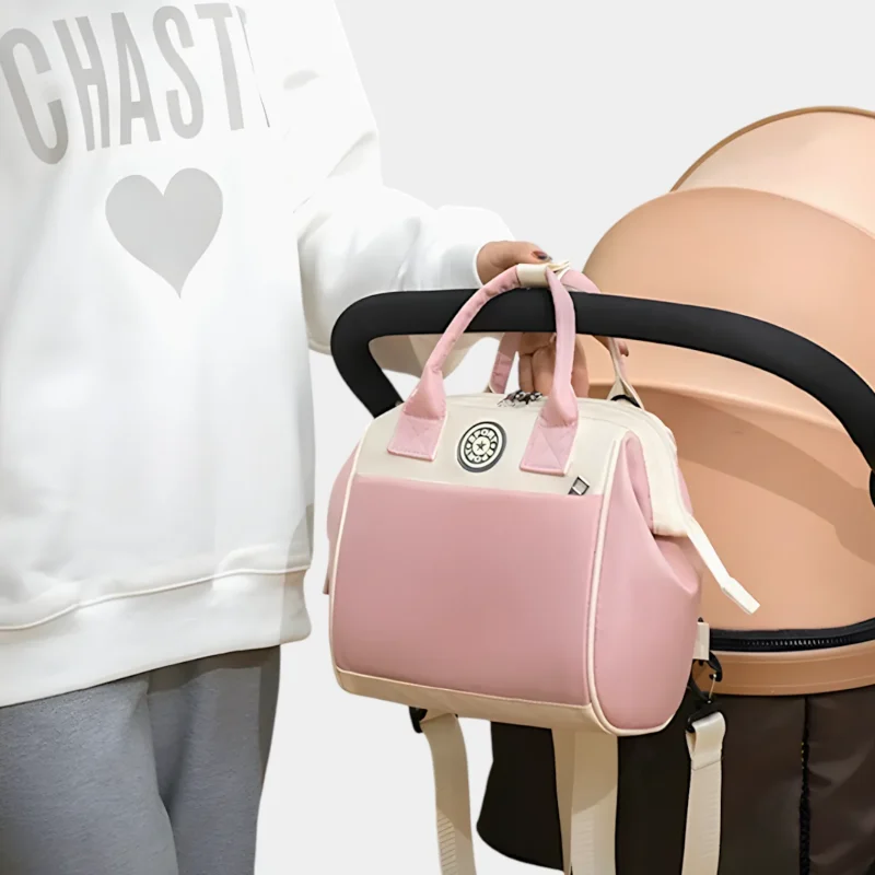 sac banane langer rose pâle pastel accroché à une poussette