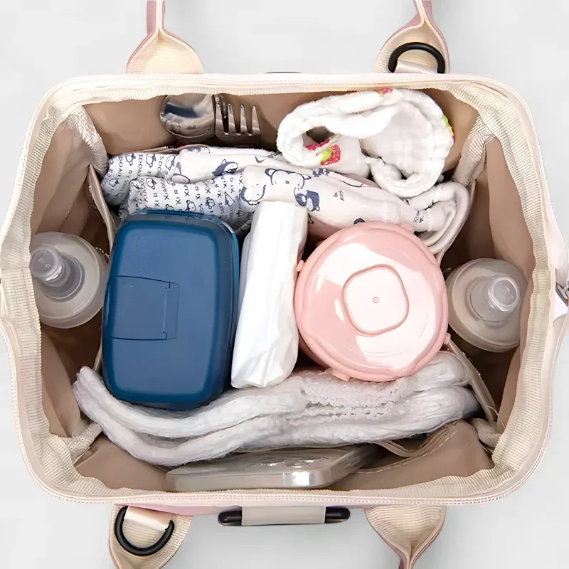 sac banane langer rose couches et biberons de bébé à l'interieur