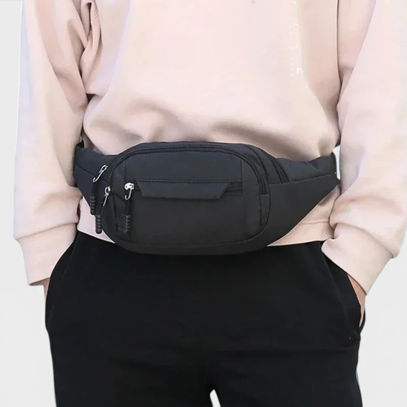 Sac banane nylon noir porté à la taille de face, au style sport casual