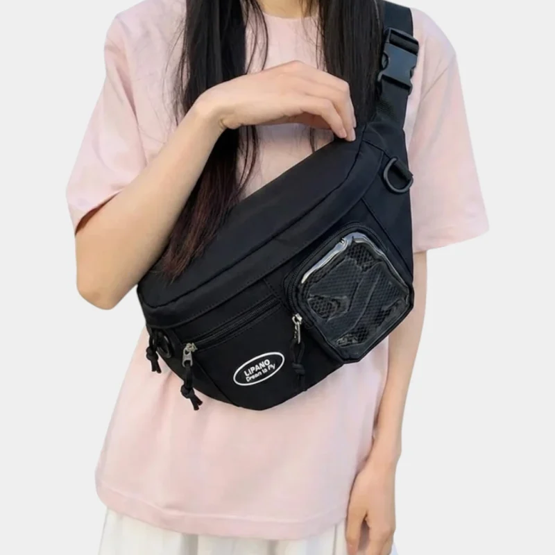 Sac banane noir en nylon porté en bandoulière croisée par une femme, de face au style streetwear casual