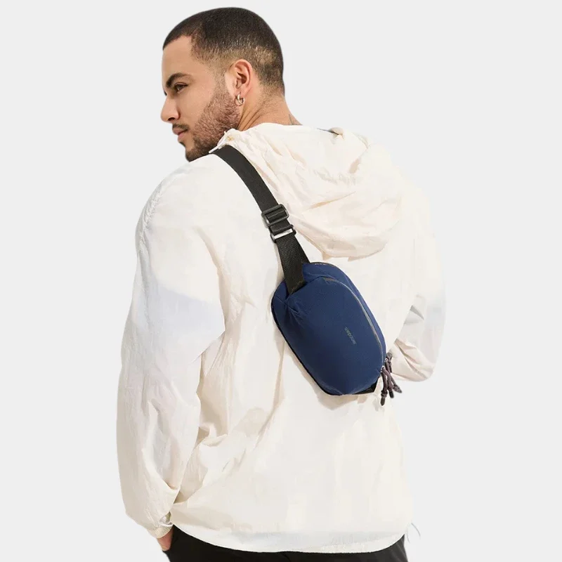 Sac banane nylon bleu marine porté en bandoulière dans le dos par un homme au style gorpcore