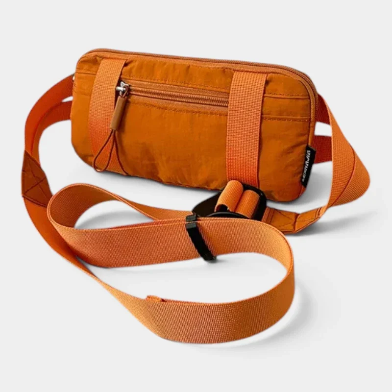 Petit sac banane nylon orange posé de face, avec une sangle réglable à boucle plastique noire