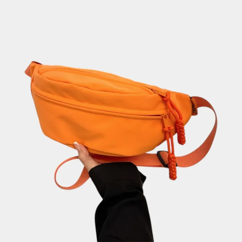 sac banane orange porté dans une main par une femme