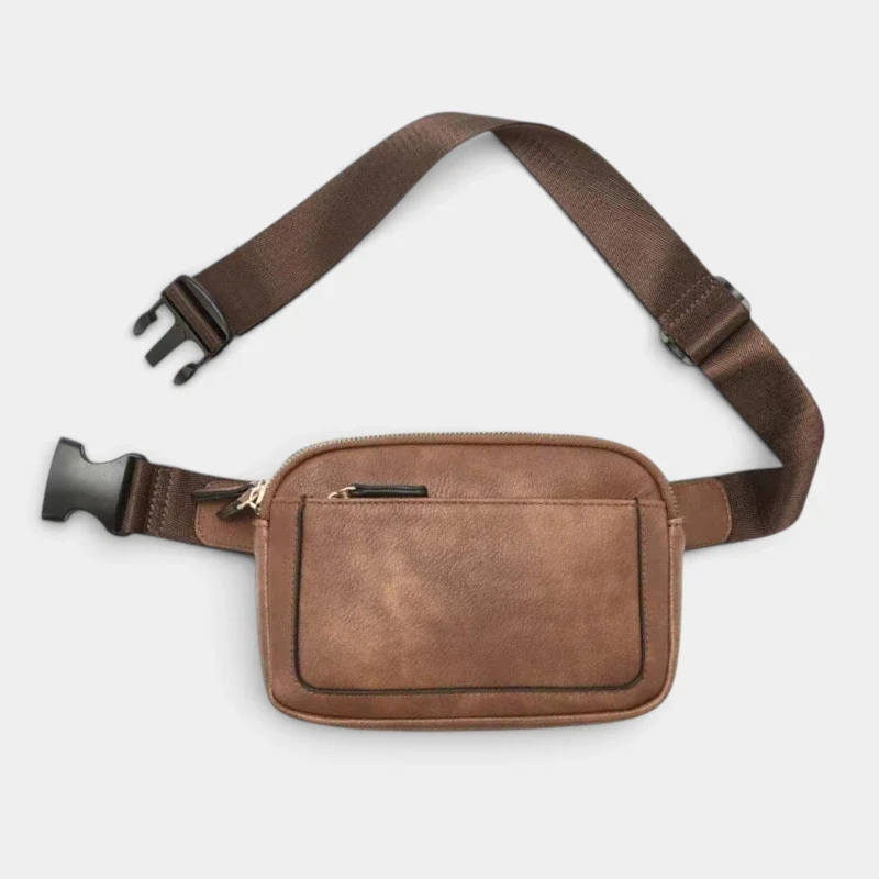 Sac banane en cuir marron vintage posé à plat de face, avec une sangle réglable à boucle plastique