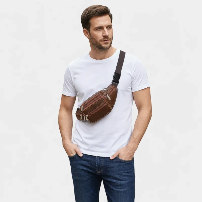 Sac banane en cuir cognac porté en bandoulière par un homme de face au style casual-chic