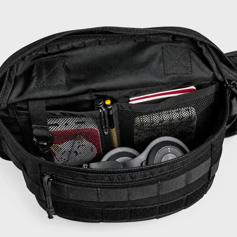 Sac banane tactique en nylon noir ouvert avec poches intérieures en filet garnies d'un casque audio et de stylos