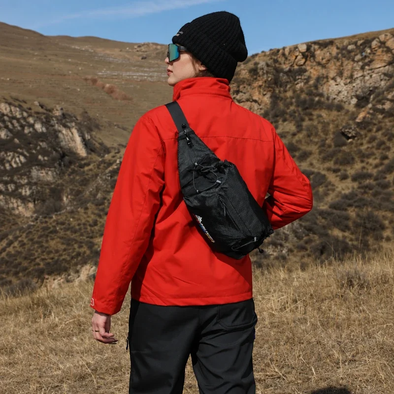 Sac banane noir porté en bandoulière dans le dos par une femme lors d'une randonnée en montagne