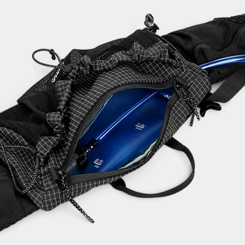 Sac banane noir en ripstop quadrillé ouvert sur sa poche principale contenant une poche à eau