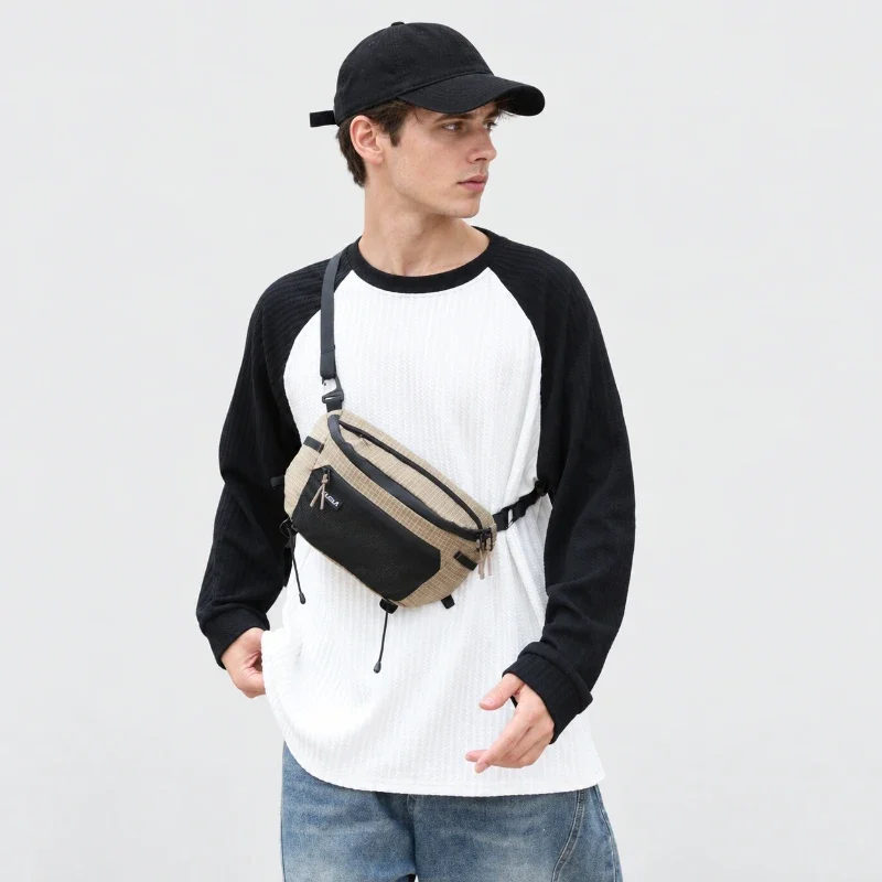 Sac banane ripstop beige quadrillé porté en bandoulière sur le torse par un homme de face