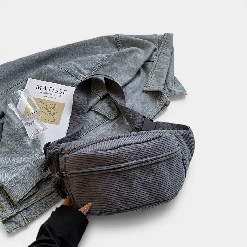 Sac banane en velours côtelé gris ardoise posé de face, avec sangle unie et clip en plastique noir