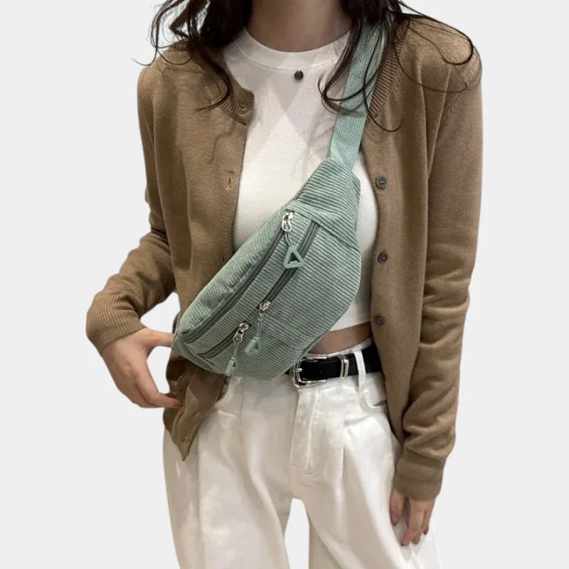 Sac banane velours côtelé vert porté en bandoulière par une femme de face avec un style casual chic