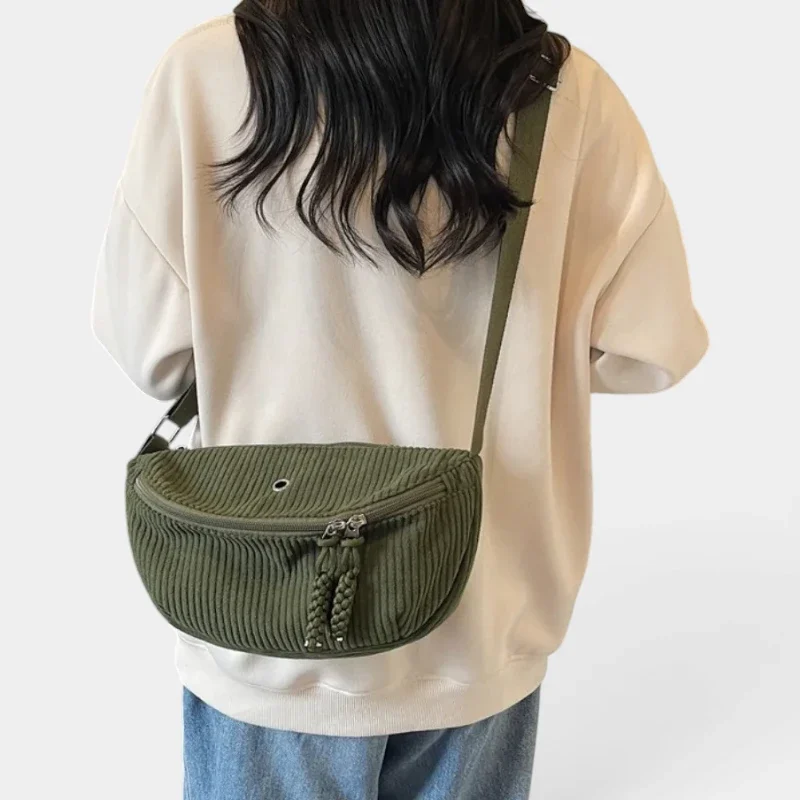 Sac banane en velours côtelé vert kaki porté en bandoulière dans le dos par une femme au style casual-chic