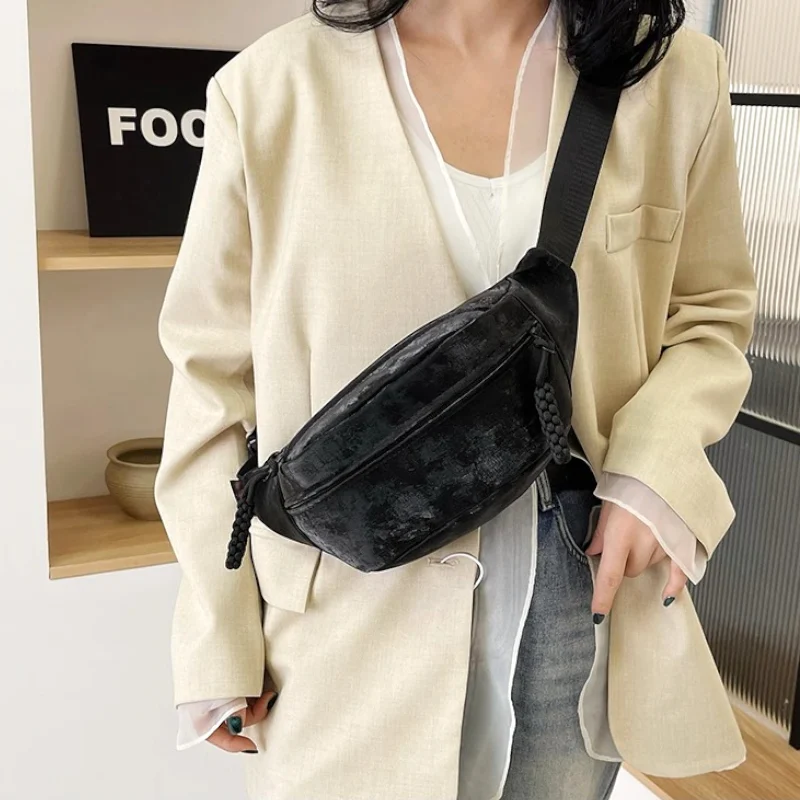 Sac Banane Velours Lisse noir porté à l'épaule avec un style casual en velours