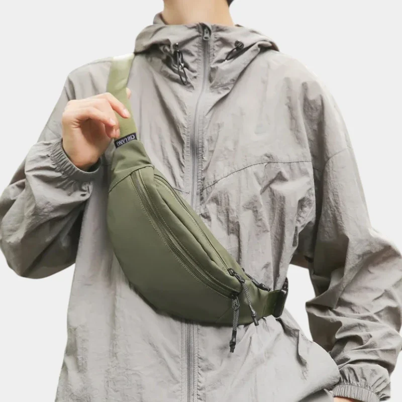 Sac banane nylon satiné vert kaki porté en bandoulière sur la poitrine avec sangle assortie